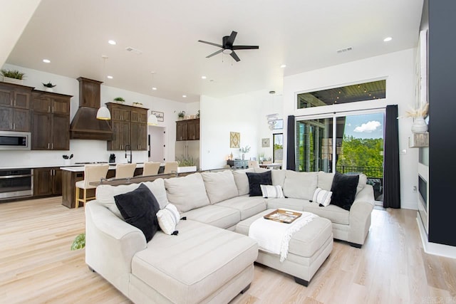 living room with ceiling fan and light hardwood / wood-style flooring