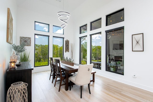 dining area featuring light hardwood / wood-style floors and a towering ceiling