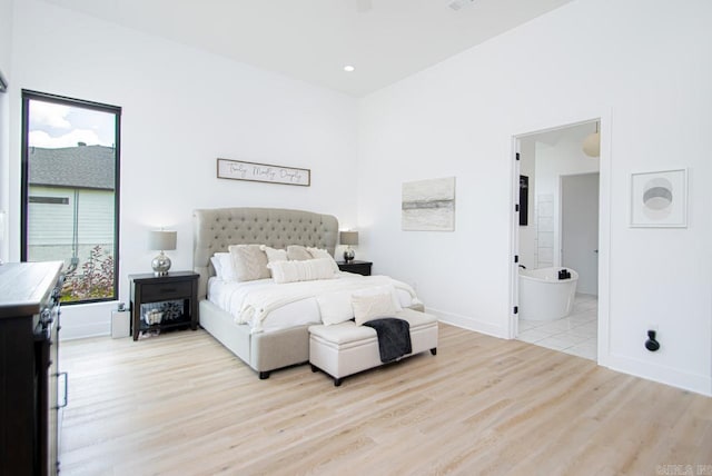 bedroom featuring light hardwood / wood-style flooring and connected bathroom