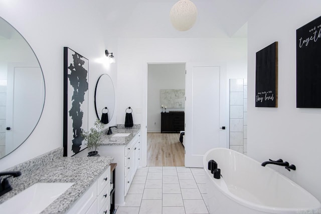 bathroom with vanity, a tub to relax in, and hardwood / wood-style floors