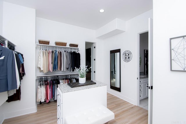 walk in closet with light hardwood / wood-style floors