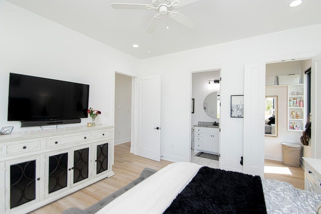 bedroom with ceiling fan, light wood-type flooring, and ensuite bath