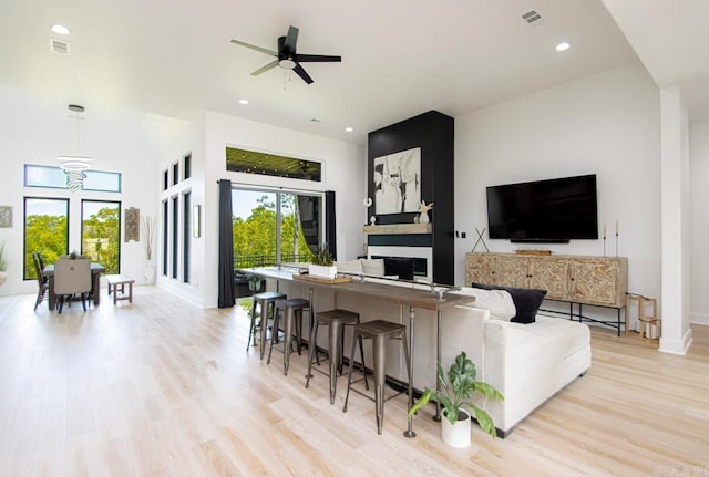 living room with light wood-type flooring and ceiling fan