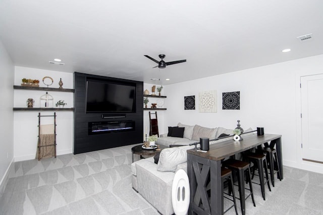 carpeted living room with ceiling fan