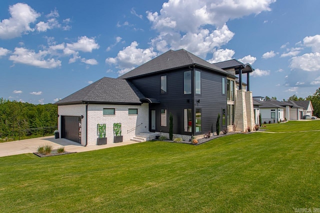 rear view of property featuring a yard and a garage