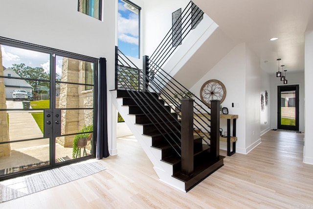 staircase featuring a high ceiling and wood-type flooring