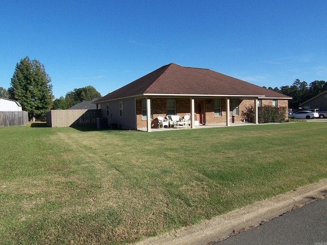 back of property with a yard, central AC, and a shed