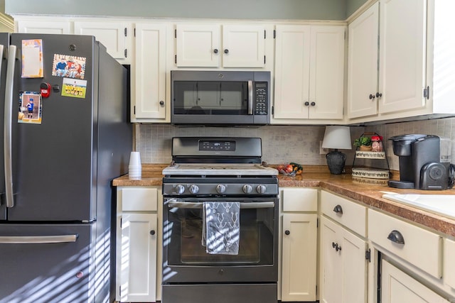 kitchen featuring white cabinetry, appliances with stainless steel finishes, and decorative backsplash