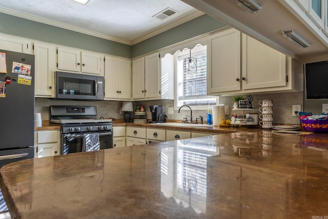 kitchen featuring sink, a textured ceiling, stainless steel appliances, crown molding, and decorative backsplash