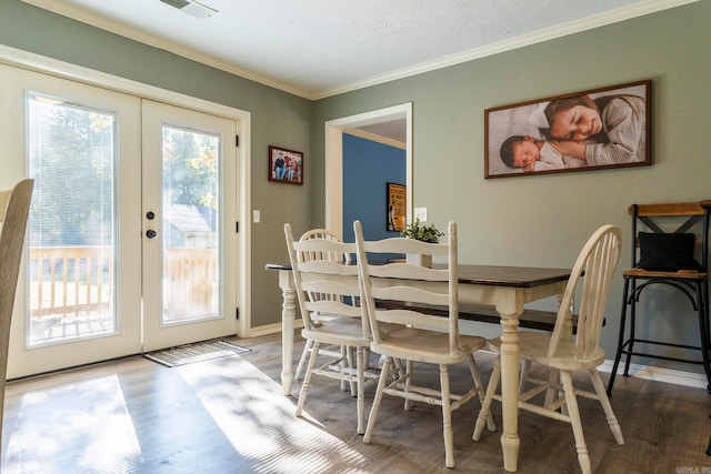 dining room featuring french doors, hardwood / wood-style flooring, ornamental molding, and a textured ceiling