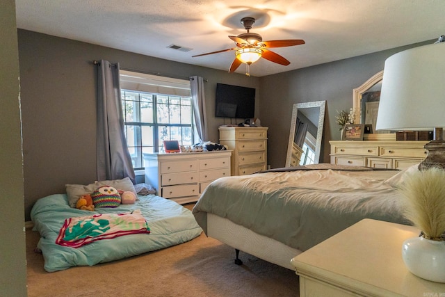 bedroom with a textured ceiling, carpet, and ceiling fan