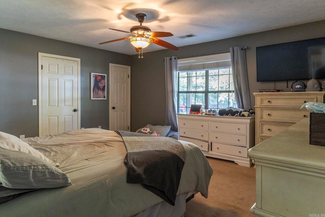 carpeted bedroom with a textured ceiling and ceiling fan