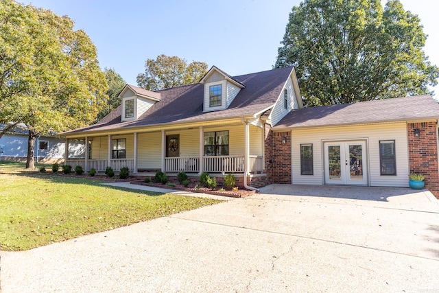 new england style home with a front yard and covered porch