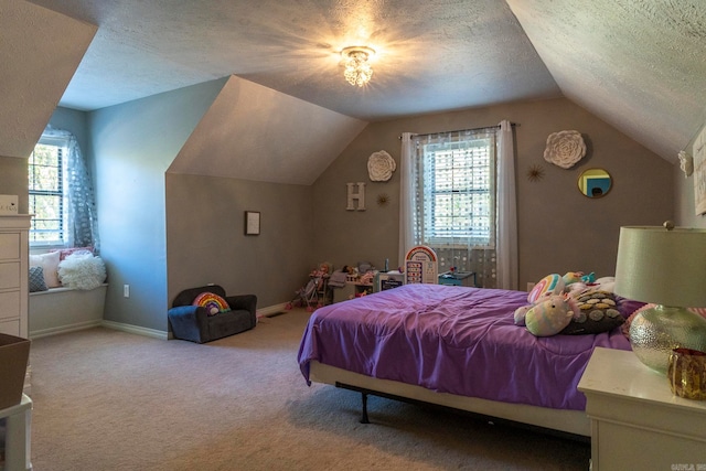 bedroom featuring light carpet, multiple windows, a textured ceiling, and vaulted ceiling