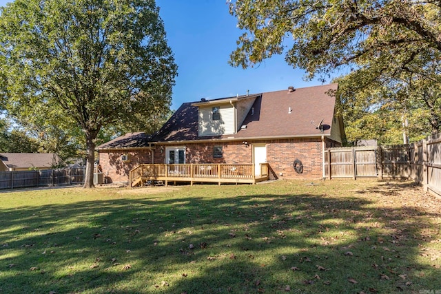 rear view of property with a deck and a lawn