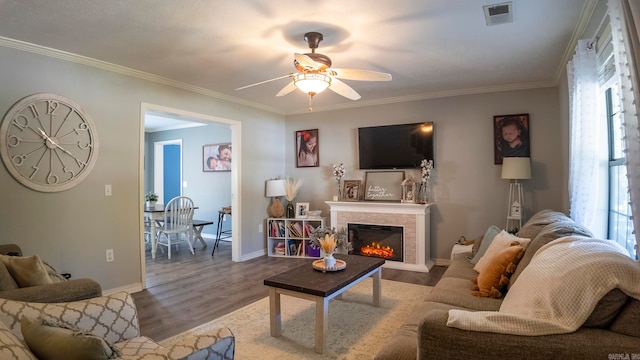 living room featuring crown molding, wood-type flooring, and ceiling fan