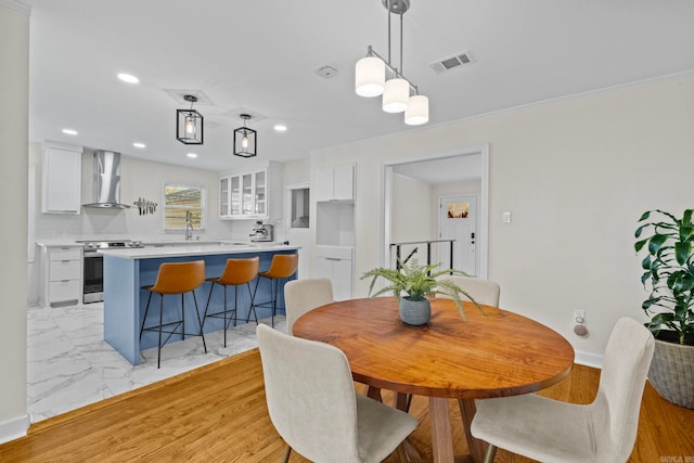 dining space with sink and light hardwood / wood-style flooring