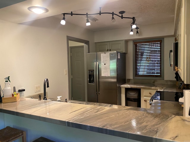 kitchen with gray cabinets, track lighting, appliances with stainless steel finishes, and a textured ceiling