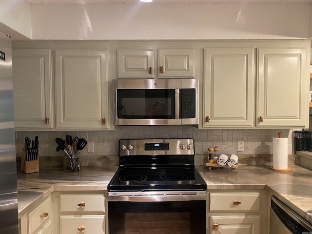 kitchen featuring white cabinetry, tasteful backsplash, appliances with stainless steel finishes, and stainless steel counters