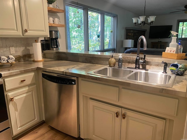 kitchen with light wood-type flooring, a healthy amount of sunlight, sink, and stainless steel dishwasher