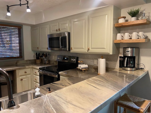 kitchen featuring white cabinetry, tasteful backsplash, electric range, and a breakfast bar area