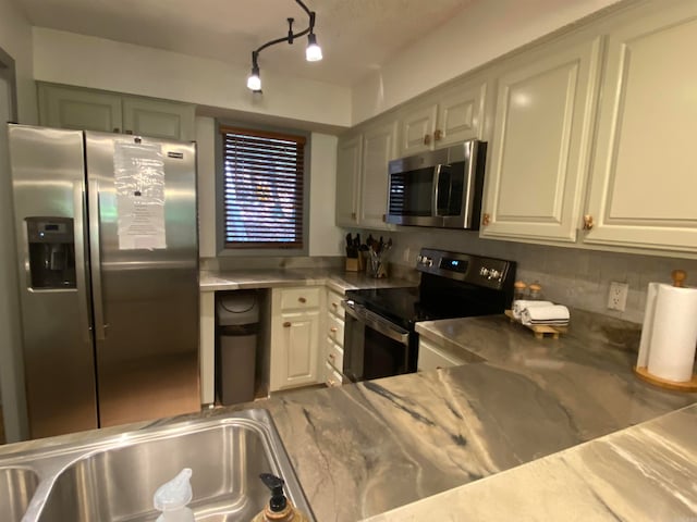 kitchen featuring white cabinetry, stainless steel appliances, sink, and backsplash