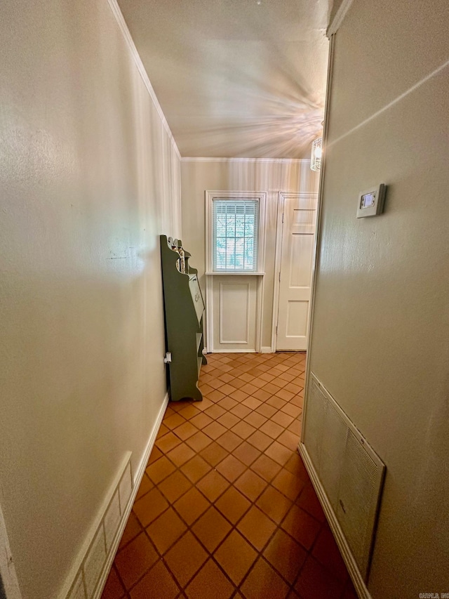 hallway featuring crown molding and tile patterned flooring