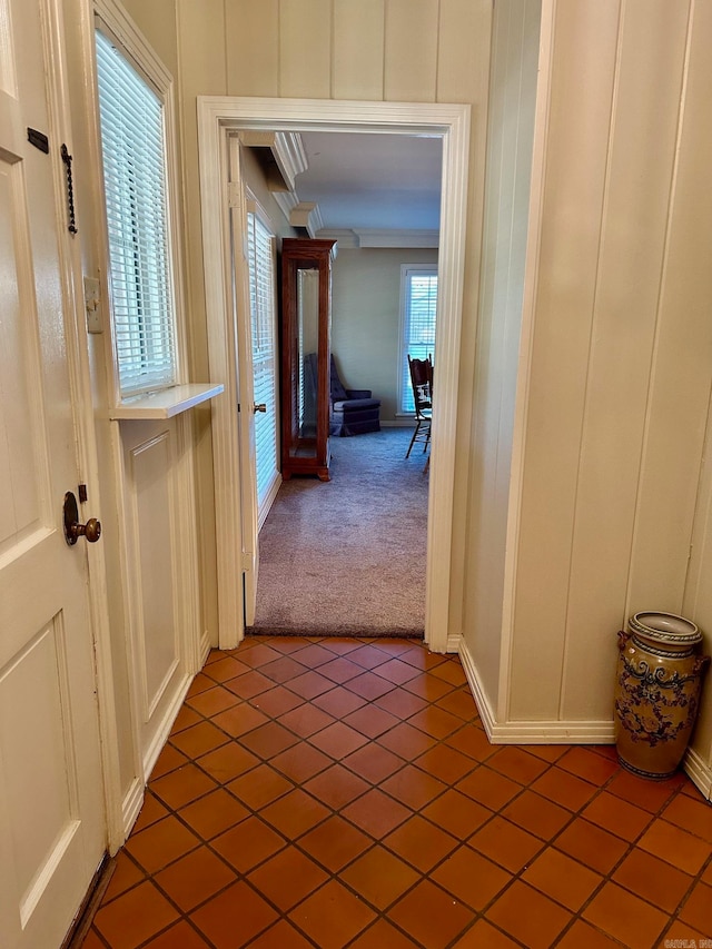 corridor with tile patterned floors and ornamental molding