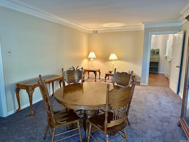 carpeted dining room featuring ornamental molding