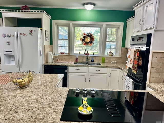 kitchen with decorative backsplash, white cabinets, black appliances, and sink