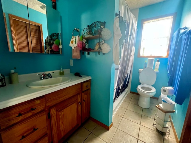 bathroom with a textured ceiling, toilet, vanity, a shower with curtain, and tile patterned flooring