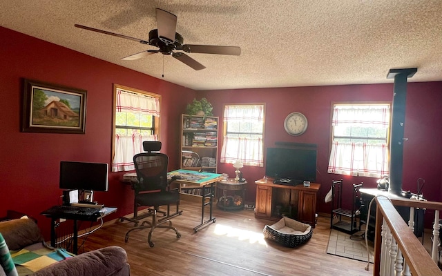 home office featuring a textured ceiling, light wood-type flooring, and a healthy amount of sunlight