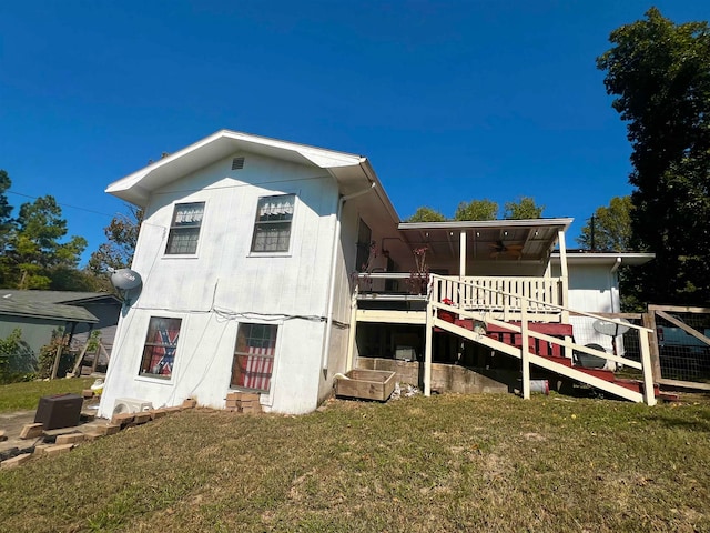 rear view of house with a yard and ceiling fan