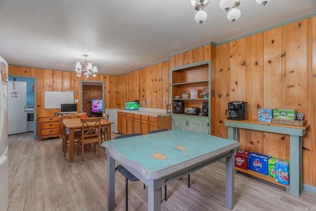 playroom with a chandelier, light wood-style flooring, and wooden walls