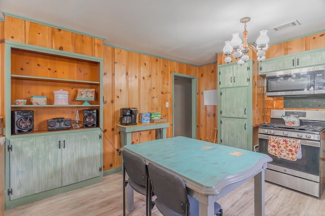 kitchen featuring a chandelier, visible vents, appliances with stainless steel finishes, ornamental molding, and light wood finished floors