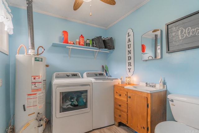 laundry room featuring water heater, ornamental molding, a sink, separate washer and dryer, and laundry area