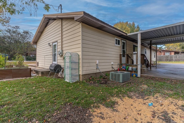 view of home's exterior featuring a garden, fence, a lawn, and central AC