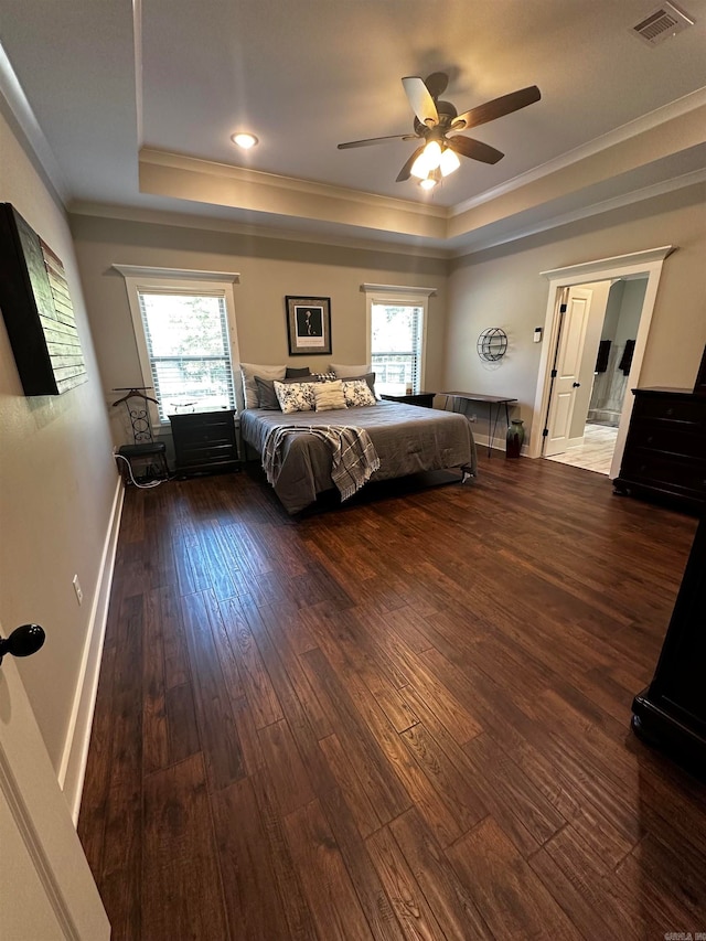 unfurnished bedroom with ornamental molding, dark wood-type flooring, a raised ceiling, and ceiling fan