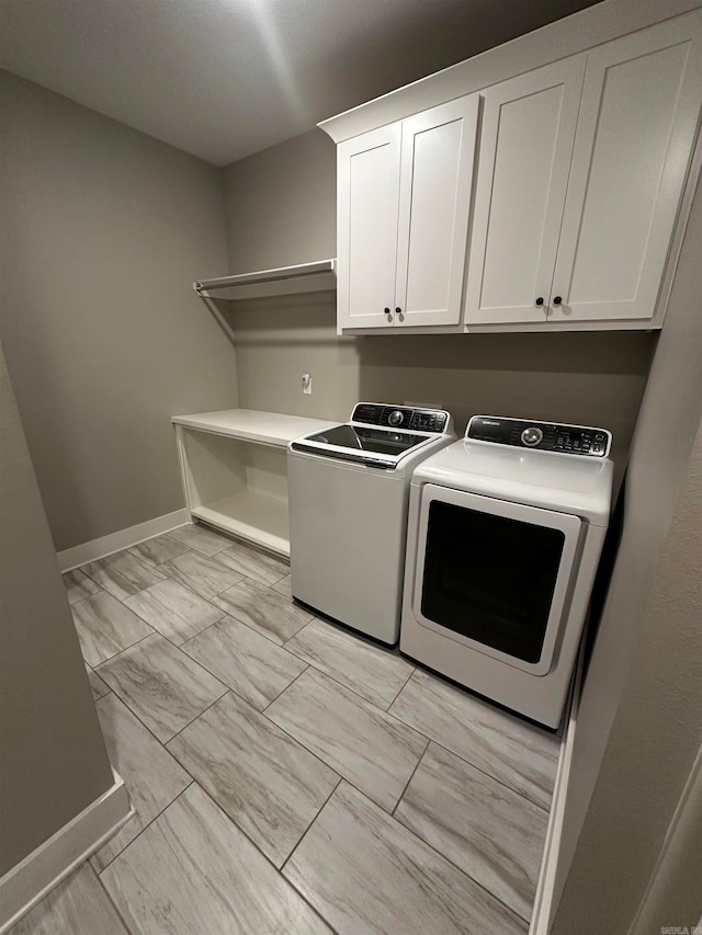 washroom featuring cabinets and washing machine and dryer