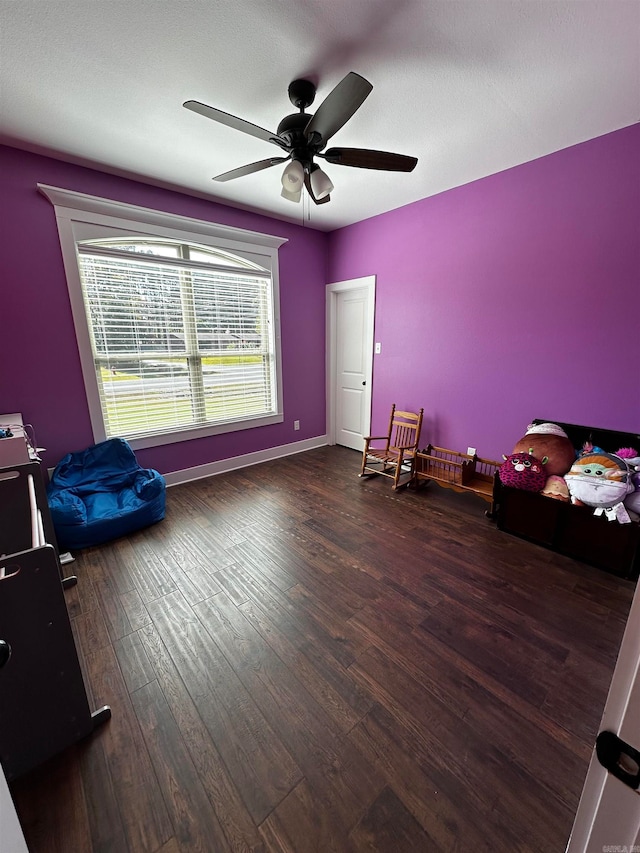 misc room with dark wood-type flooring, ceiling fan, and a textured ceiling