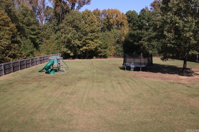 view of yard with a playground and a trampoline