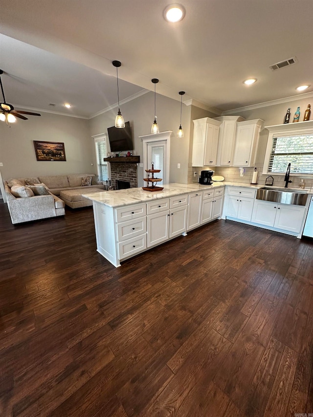 kitchen with kitchen peninsula, white cabinets, sink, and dark hardwood / wood-style floors