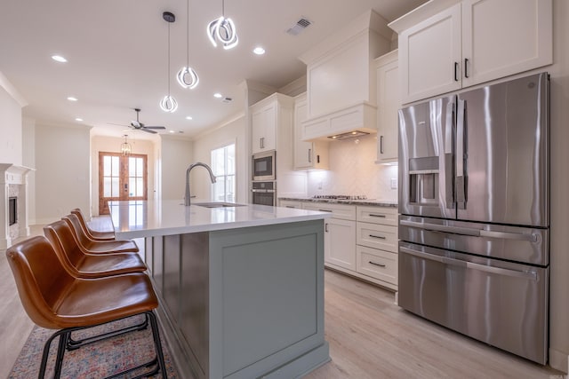 kitchen featuring decorative backsplash, crown molding, a sink, appliances with stainless steel finishes, and light countertops