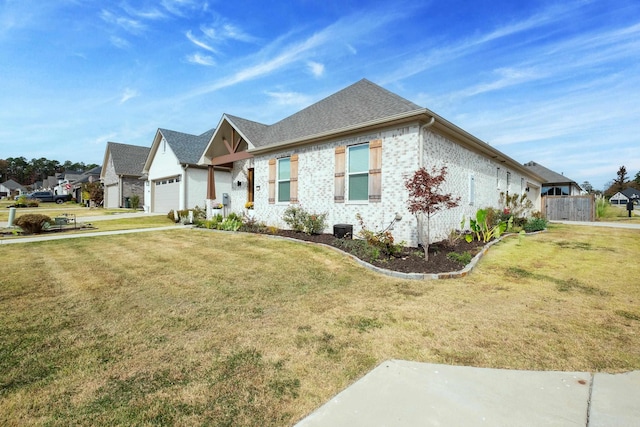 view of front facade featuring a front yard, a residential view, brick siding, and a garage