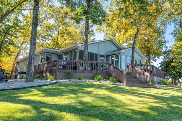 rear view of house featuring a deck and a yard