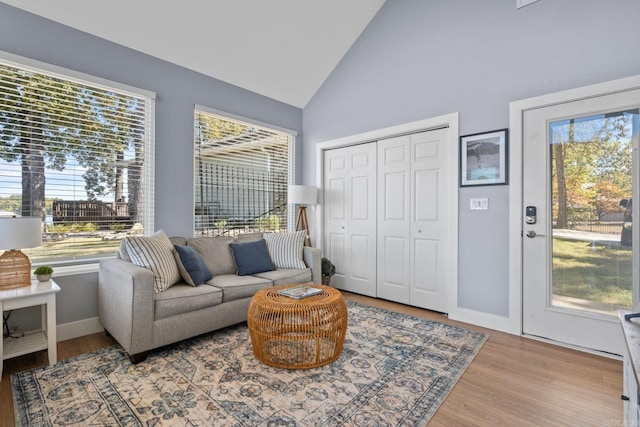 sitting room with light hardwood / wood-style floors and high vaulted ceiling