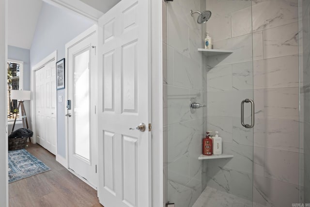 bathroom featuring a wealth of natural light, hardwood / wood-style floors, and a shower with shower door