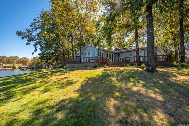 view of yard with a deck with water view