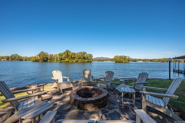 view of patio / terrace featuring a dock, a fire pit, and a water view