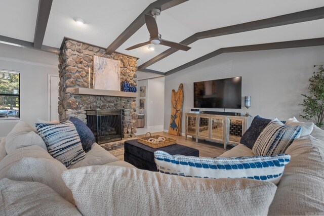 living room with lofted ceiling with beams, hardwood / wood-style flooring, a fireplace, and ceiling fan